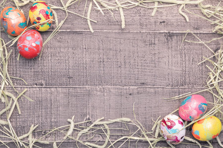 Colorful easter eggs on wooden background with space for text.の写真素材