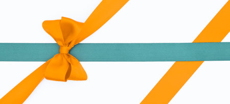 Orange ribbon with bow isolated on white background, clipping path included.の写真素材