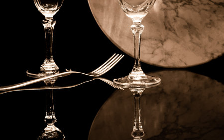 Wine glasses and fork on a black background. Toned.の写真素材