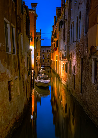 Night view of Venice canal with gondolas and old houses in Italyの写真素材