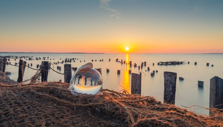 Sunset over the sea in a glass ball with a sunset in the backgroundの写真素材