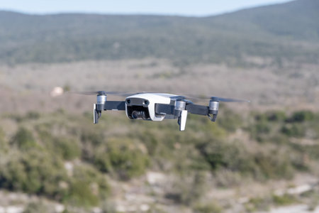 Drone with digital camera flying in the air over a rural landscapeの写真素材