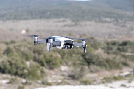Drone with digital camera flying in the sky over the mountains.の写真素材