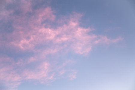 Blue sky with pink clouds in the evening. Beautiful natural background.の写真素材