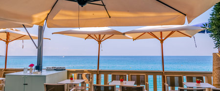 Tables and chairs of a restaurant on the coast of the Mediterranean Seaの写真素材