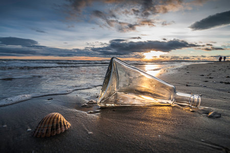 Bottle on the beach at sunset. Concept imageの写真素材