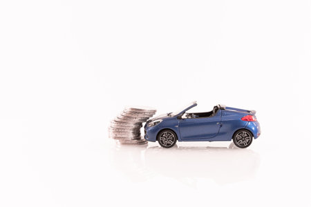 Model car with coins on a white background, concept of saving moneyの写真素材
