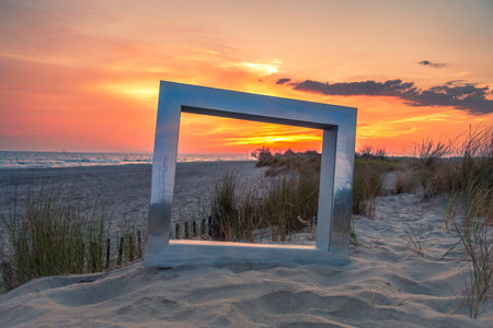 Sunset on the beach with a picture frame in the foreground.の写真素材
