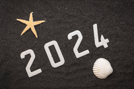 Happy New Year 2024: New Year 2024 concept on the black sand of a beach and the 2024 numbers seen from above.の写真素材