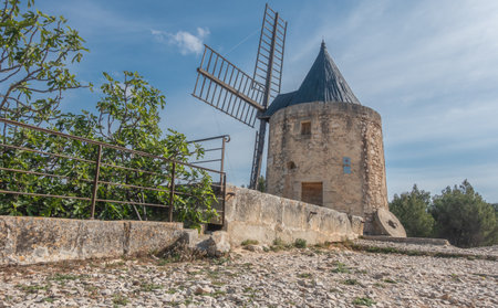 Old windmill on the top of a rock with blue sky backgroundの写真素材