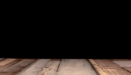 Wooden table top on black background with space for your text.