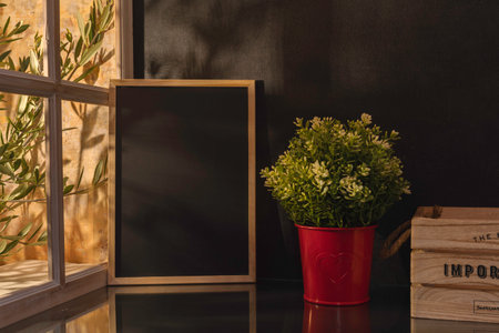Mockup of blackboard and vase with green plant on table