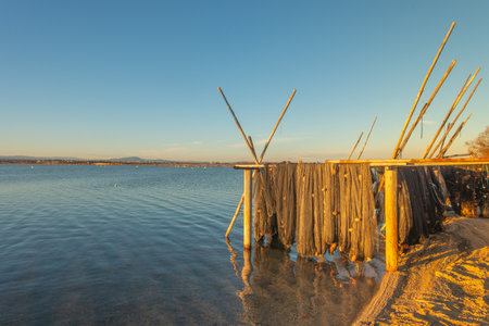 Fishing nets on the shore of the lake at sunset in winterの写真素材