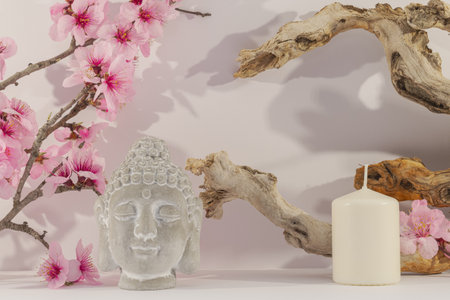Buddha statue, candle and sakura flowers on white backgroundの写真素材