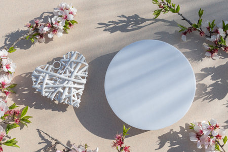 Flat lay composition with white plates, heart and flowers on a beige background.の写真素材