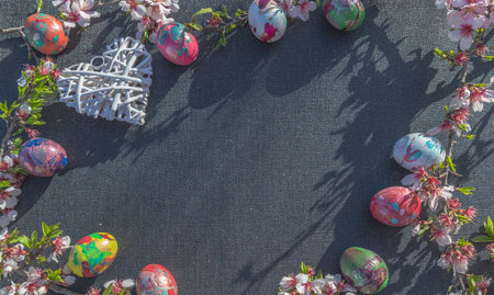 Easter eggs and spring flowers on a black background, top viewの写真素材