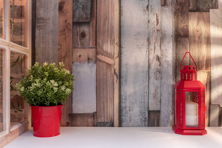 Red lanterns and flowers on a wooden background with a window.の写真素材