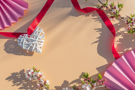 Creative layout made of hearts and paper fans on beige background. Flat lay, top view. Valentine's day concept.の写真素材