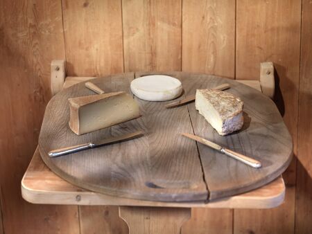 rural style, cheese on wood plate with silver knivesの写真素材