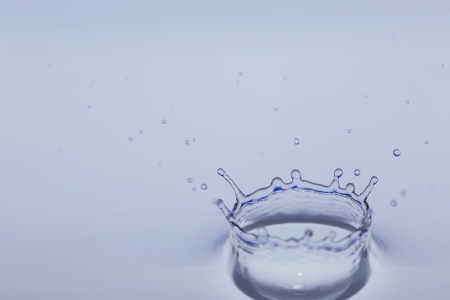 clear fresh water drop falling in a big basinの写真素材