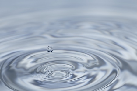 clear fresh water drop falling in a big basinの写真素材