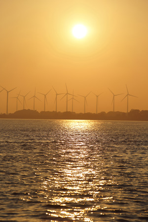 coast onshore wind power station in sunsetの写真素材
