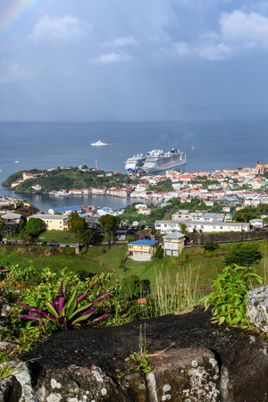 View of the cozy seaside town and the misty tropical sea with cruise ships standing at the pier.の写真素材