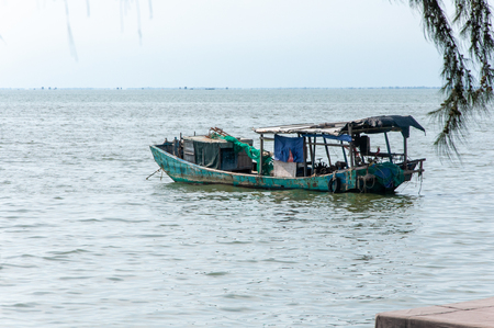 BEIHAI, CHINA - JUN, 2013: An old fishing boat drifting on the calm surface of the oceanのeditorial素材
