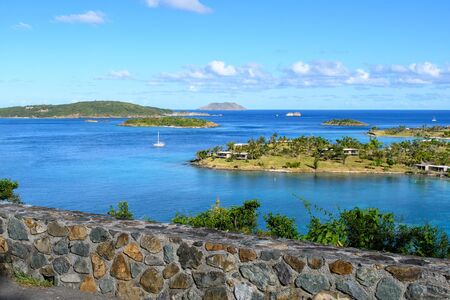 Wonderful view of the blue sea with tropical Islands, yachts, clouds on the horizon and a stone parapet in the foregroundの写真素材