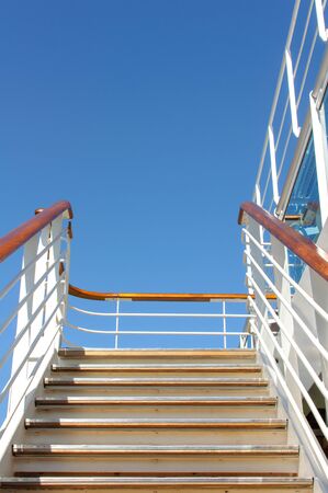 Stairs with railing to climb to the upper deck on a cruise ship against the blue sky.の写真素材