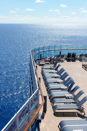 View from the deck of a cruise ship in the ocean. Seating area for passengers, chairs and sun loungers. Sunbathe.の写真素材
