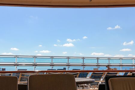 View from the deck of a cruise ship in the ocean. Seating area for passengers, chairs and sun loungers. Sunbathe.の写真素材
