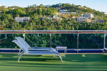 View from the deck of a cruise ship in the ocean. Seating area for passengers, chairs and sun loungers. Sunbathe.の写真素材