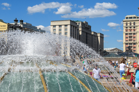 MOSCOW, RUSSIA - JULY, 2018: The heat in the city. People relax by the fresh fountain in the city garden in hot summer weather.のeditorial素材