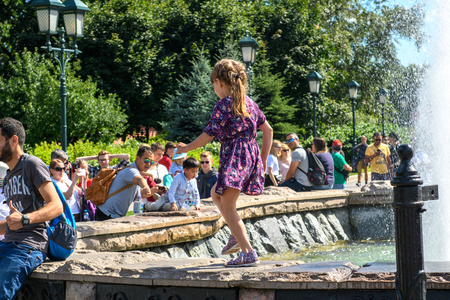 MOSCOW, RUSSIA - JULY, 2018: The heat in the city. Baby Girl playing at the fountain during the hot summer weather.のeditorial素材