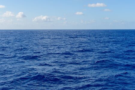 Blue sky with white clouds over the azure waters of the ocean.の写真素材