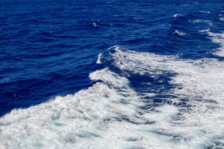 Blue ocean wave with white sea foam on top.の写真素材