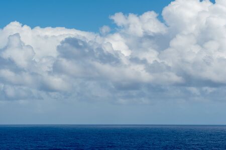 Blue sky with white clouds over the azure waters of the ocean.の写真素材