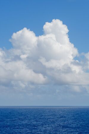 Blue sky with white clouds over the azure waters of the ocean.の写真素材