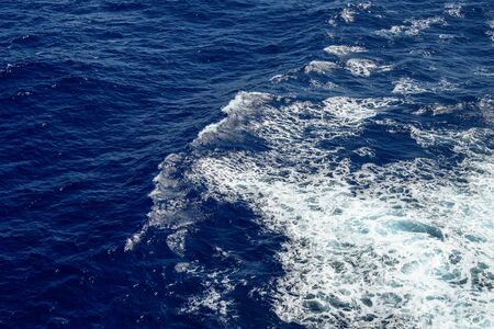 Blue ocean wave with white sea foam on top.の写真素材