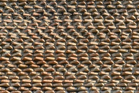 A fragment of the original brickwork of burnt bricks built by Ancient Rome. Background. Pattern. Ocher, brown.の写真素材