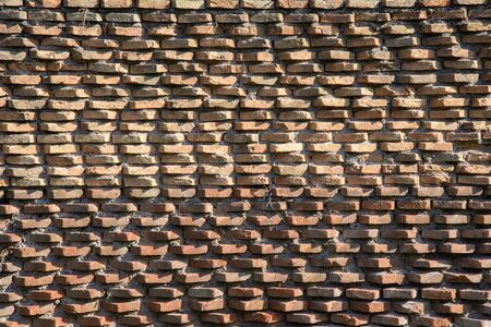 A fragment of the original brickwork of burnt bricks built by Ancient Rome. Background. Pattern. Ocher, brown.の写真素材