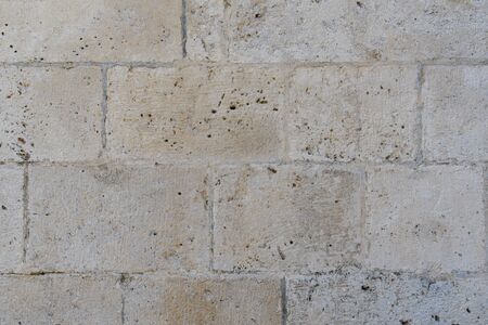 Fragment of an old stone wall of an ancient Roman temple made of processed sandstone. Background. Gray.の写真素材