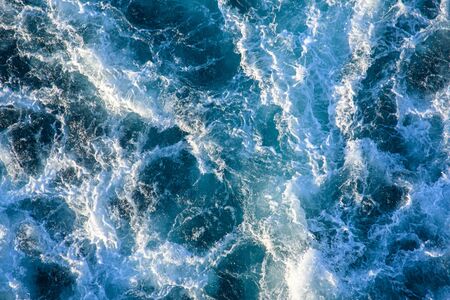 Seething waves with foam backlit by the setting sun. Transparent. Navy blue. Blue. Background. Pattern.の写真素材