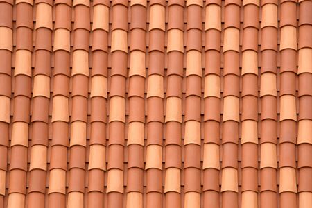Fragment of a tiled roof. Clay tiles. Background. Pattern. Terracotta. Gray. Ocher.の写真素材