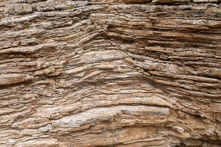 Fragment of a layered geological rock. Background. The color of ocher.の写真素材
