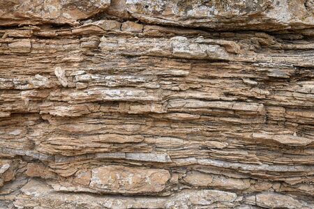 Fragment of a layered geological rock. Background. The color of ocher.の写真素材