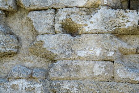 A fragment of the old stone wall of one of the temples of ancient Greek Olympia. Antique masonry.の写真素材