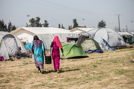 Idomeni, Paeonia, Kilkis regional unit of Central Macedonia / Greece - March 22 2016: two women carrying water in their refugee camp.のeditorial素材