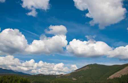 White clouds over the hillsの写真素材